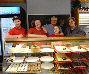 Members of staff at the Betty Kaye bakery, stood behind a counter filled with baked goods