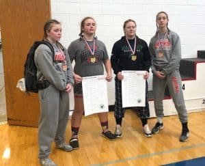 Four girls at state wrestling tournament with awards